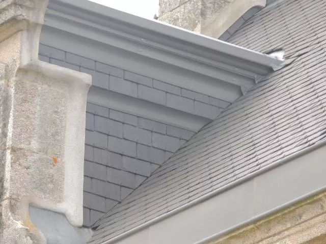 Détail de l’angle du toit avec une finition de toiture en ardoise.