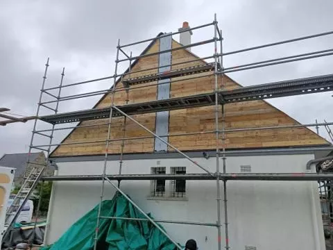 Toit en rénovation avec échafaudage en place, en préparation pour l’installation du toit.