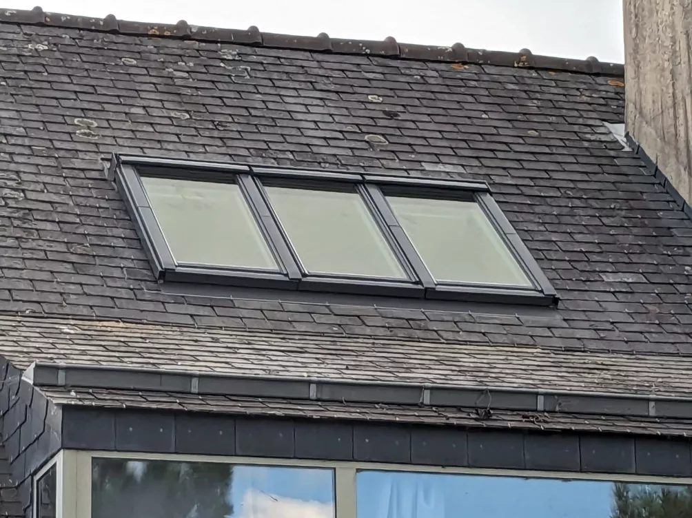 Toiture en ardoise avec fenêtres de toit installées, vue extérieure.